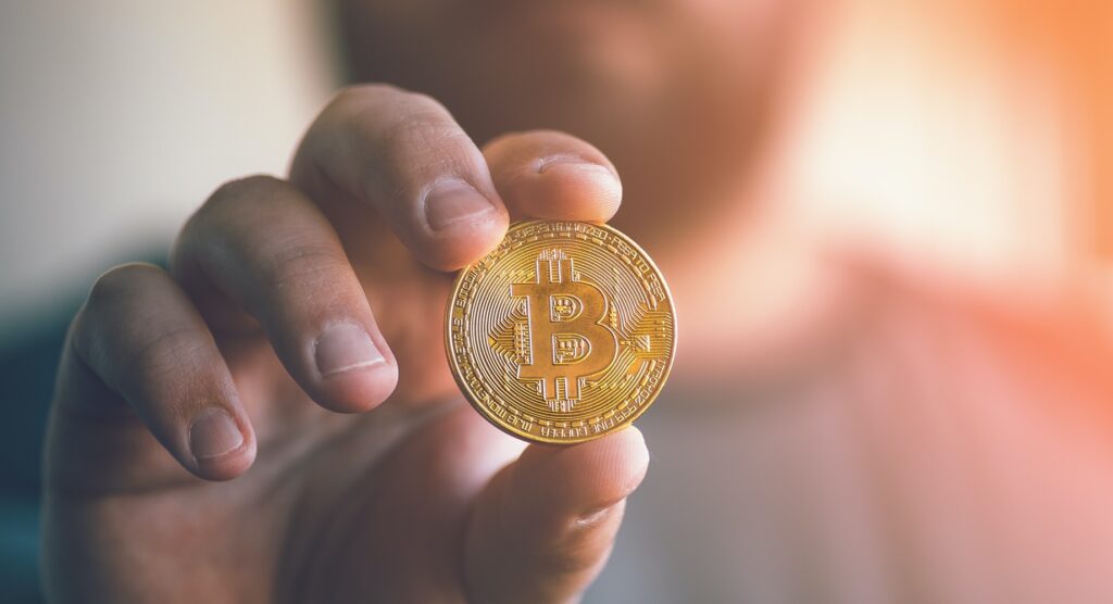 Man holding bitcoin-style coin