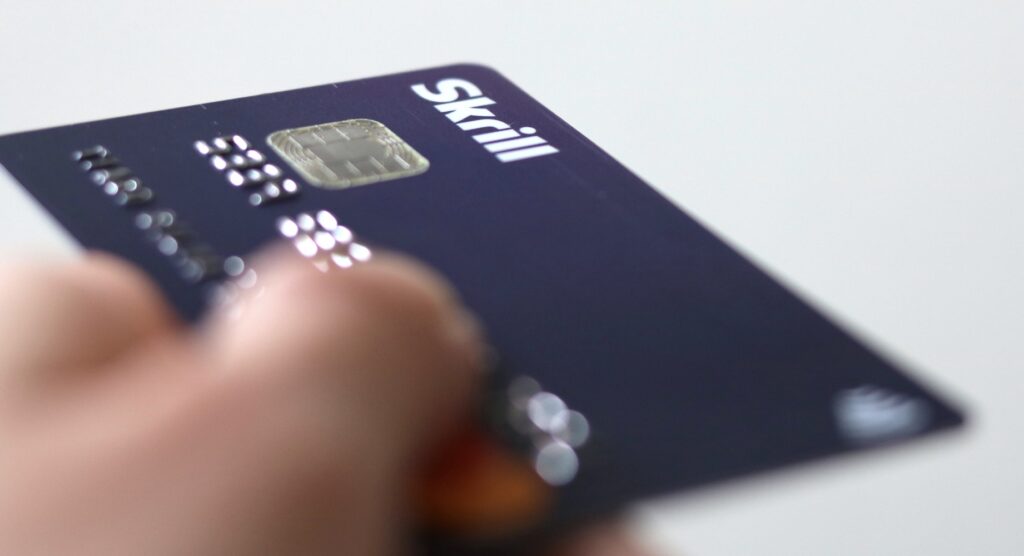 Person holding Skrill card